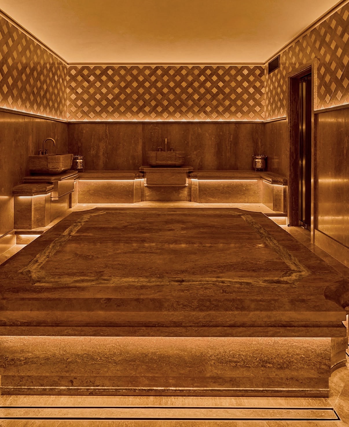 Travertine hammam chamber with warm lattice-work walls